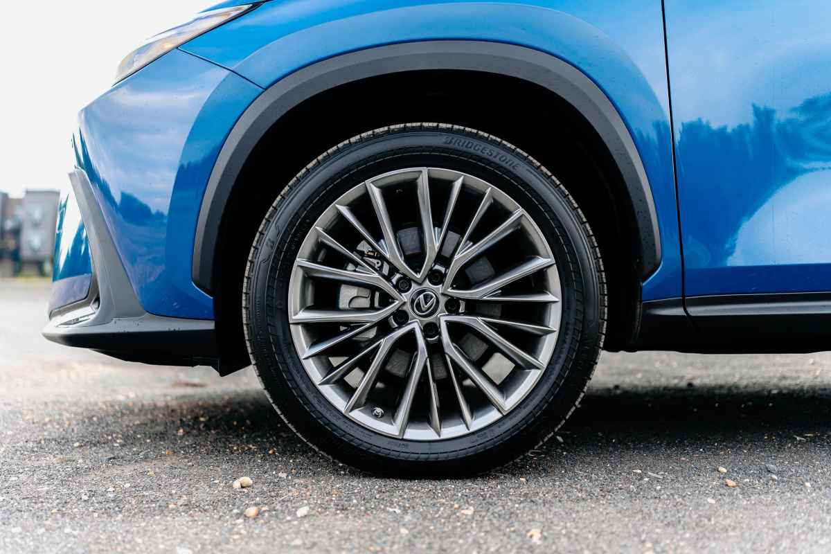 Mėlyno automobilio priekinio rato ir dalies sparno detalė.
